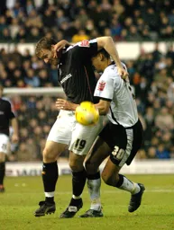 Steven Howard challenges for the ball with a Derby player