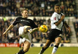 Steven Howard stretches for the ball watched closely by a Derby player