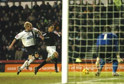 Dean Morgan glides into the box challenged by a Derby defender