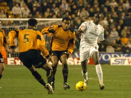 Enoch Showunmi with ball challenged by two Wolves players