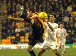 Carlos Edwards and a Wolves player challenge for the ball