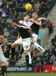 David Bell and Kevin Nicholls both go up for a header