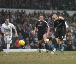 Rowan Vine strikes the ball watched by Steven Howard