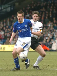 Chris Coyne challenges a Leicester player for the ball