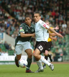 Dean Morgan and a Plymouth player battle for the ball
