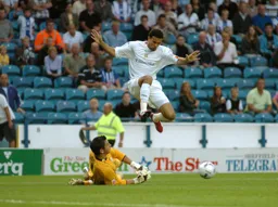 Carlos Edwards leaps over Brad Jones