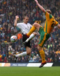 Former Hatter Gary Doherty clears the ball away from Rowan Vine