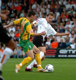 Markus Heikkinen and Jason Koumas battle for possession