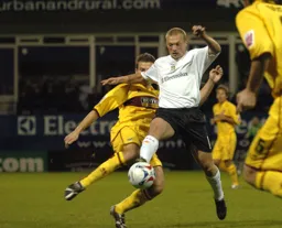 A determinded looking Warren Feeney wins the ball