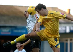 Carlos Edwards and Danny Pugh in a heading duel