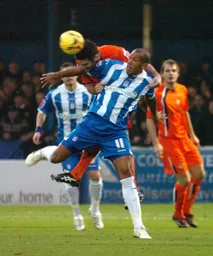 Chris Coyne goes over the top of Chris Iwelumo to win a header