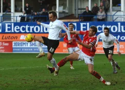 Ahmet Brkovic gets in front of Paul Reid to control the ball