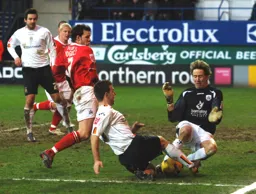 Nick Colgan goes in feet first to deny Keith Keane