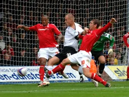 Jaroslaw Fojut attacks the ball whilst having his shirt pulled