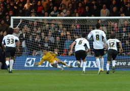 Dean Brill saves a penalty from Matt Harrold