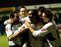 Calvin Andrew is surrounded by jubilant players after scoring
