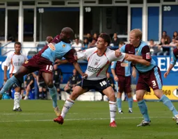 Chris Martin is grappled by a pair of Notts defenders