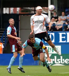 Sam Parking heads the ball off target