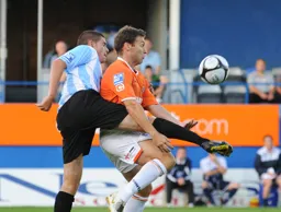 An awkward moment for Kevin Gallen as he is challenged from behind