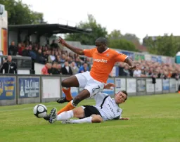 A sliding tackle stops Adam Newton in his tracks