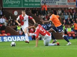 Adam Newton knocks the ball past Gavin Caines