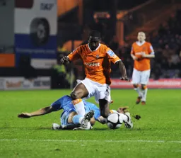 A sliding tackle stops Adam Newton