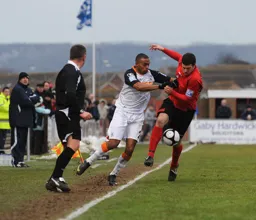 Matthew Barnes-Homer tight against the touchline tussles for the ball
