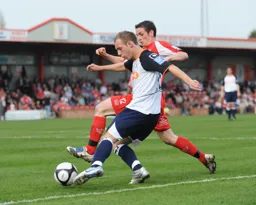 Jake Howells gets past Jake Sheridan to deliver a cross into the box