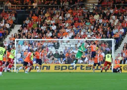Anxious faces in the Kenilworth Road end as Kevin Pilkington has to deal with a cross