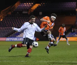 A wounded John-Paul Kissock makes a firm challenge on Sam Belcher