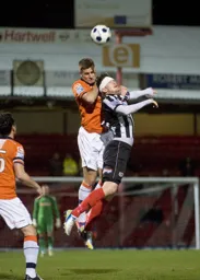 Janos Kovacs heads the ball away from danger