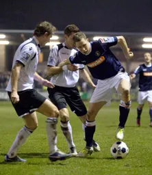 Dave Martin takes on two defenders