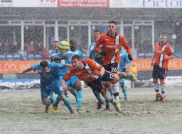 Simon Ainge dives in to send a header towards goal