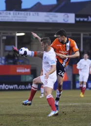 A grimace on the face of Jonathan Smith as he challenges for the ball with Dan Gray