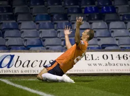 Paul Benson knee slides in celebration after putting the Hatters ahead