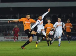 Andre Gray holds off his man