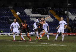 Cameron McGeehan gets in a header watched by Nathan Oduwa