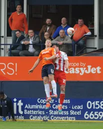 Scott Grifiths rises above the Stevenage player