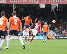 Tyreeq Bakinson heads the ball forward