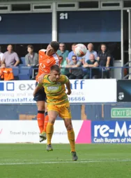 Jake Gray gets above Otis Khan to head the ball forward