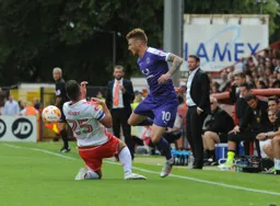 Jordan Cook knocks the ball past former Hatter Ronnie Henry