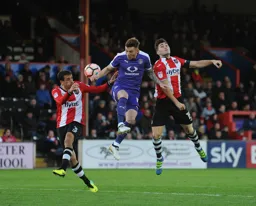 Jordan Cook gets between defenders to send a header towards goal