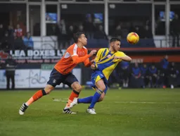 Olly Lee grabs a handful of future Hatter Jordan Clark`s shirt