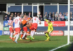 Jack King heads the ball away from the on rushing Isaac Vassell