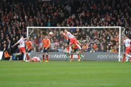 Scott Cuthbert clears the danger under pressure from former Hatter Luke Wilkinson