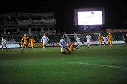 Isaac Vassell is sent crashing to the ground by former Hatter Mark O`Brien