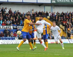 Isaac Vassell gets in a shot at goal in front of Rhys Bennett