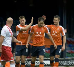 Danny Hylton gets a pat on the back from James Collins and Dan Potts after scoring the second goal