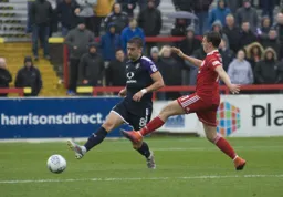 Olly Lee plays the ball forward as Sean McConville closes in