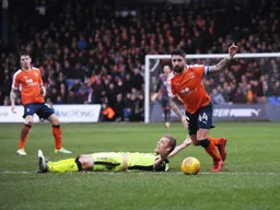 Alan Sheehan takes the ball away from a grounded former Hatter Jayden Stockley